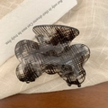 Macro shot of large butterfly hair claw clip with black grid pattern on acrylic - 7.7cm