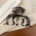 Close-up of black and white checkered acrylic hair claw clip on soft fabric texture - 9.6cm