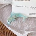 Detail showing dolphin hair clip with light blue marble pattern on wicker background - Sky Blue 7.2cm