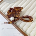 Detail of ginkgo leaf hair claw clip with amber texture and a large white pearl accent - 10cm / Wood Grain
