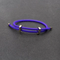 Adjustable purple braided steel wire bracelet with gold sliding metal buckles on grey surface - Deep purple
