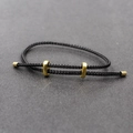 Détail du bracelet réglable en corde tressée noire avec perles coulissantes dorées - Noir