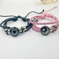 Detail van zon- en maanglashangers op de geweven armbanden voor verliefden - Zwarte Zon + Roze Maan