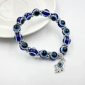 Detailansicht der blauen Evil Eye Perlen und des silbernen Hamsa Hand Anhängers am Armband - Blauer Handstil (BNS-0222-10mm)