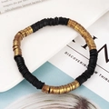 Detail van de zwarte en gouden Heishi-kralenarmband op een wit keramisch dienblad - Mat Zwart Antiekgoud Stijl (BNS-0427-Stijl 5)