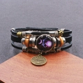 Dettaglio del bracciale zodiaco Bilancia in pelle intrecciata con perle e ciondoli in metallo - Libra