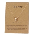 Collar con colgante de Tauro dorado en tarjeta de papel kraft con detalles zodiacales - Tauro