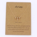 Gold Aries zodiac pendant necklace on gift card with character trait descriptions - Aries