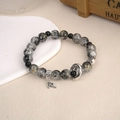 Detailed macro view of natural stone beaded bracelet with silver leaf charm and metal spacer - Vintage Bracelet Dark Color (BNS-0481)