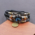 Dettaglio del bracciale zodiaco Pesci in pelle intrecciata con perline in legno e ciondoli - Pisces