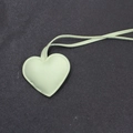 Dettaglio macro di un ciondolo a cuore in pelle verde menta con cuciture per borse - Stile Cordino / Verde
