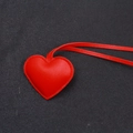 Dettaglio ravvicinato di un ciondolo a cuore in pelle rossa con cuciture coordinate - Stile Cordino / Rosso