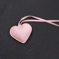 Dettaglio di un ciondolo a cuore rosa in ecopelle con cuciture curate e trama - Stile Cordino / Rosa