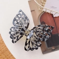 Detail of a large butterfly hair claw clip with black and white marble pattern texture - Black / 14cm