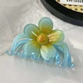 Vue détaillée d'une pince à cheveux fleur dégradée bleue avec centre jaune et dents lisses - Bleu Lac 11cm