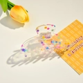 Dettaglio del fermaglio in acrilico trasparente con stelle colorate e logo YHJ-Handmade - 10.5cm / Stelle Colorate