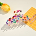 Dettaglio del fermaglio per capelli in acrilico trasparente con smiley colorati e logo - 10.5cm / Stile Sorriso
