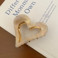 Dettaglio molletta per capelli a cuore con texture marmo champagne e montatura dorata - Bianco Perlato