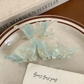 Detail of blue acetate butterfly hair claw clip with pearlescent finish on ceramic plate - 10cm / Mint Green