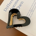 Close-up of heart-shaped hollow hair claw clip in black and gold on a vintage book - Black 6cm