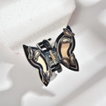 Close-up of butterfly hair claw showing black and beige patterns on white stone - Medium Hair Claw / Black and Beige Butterfly Style