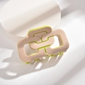 Detailansicht der zweifarbigen geometrischen Haarklammer in Beige und Neongrün - Groß / Aprikose