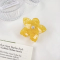 Dettaglio di un fermaglio per capelli a fiore giallo in acetato con perla centrale - Giallo / 7cm