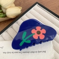 Dettaglio di un fermaglio per capelli blu con fiori rosa su un vassoio beige morbido - 10cm / Blu