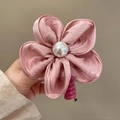 Détail d'une pince à cheveux fleur en soie rose poudré avec perle et griffe spirale - Rose