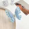 Detailed view of light blue butterfly hair claw clip with rhinestones and gold spring - Metallic Blue