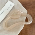 Dettaglio di un fermaglio per capelli in resina rosa trasparente con molla dorata - Rosa trasparente