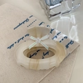 Makroaufnahme einer Haarklammer aus Acetat mit Marmortextur, weißen Blüten und grüner Schleife - 7.2CM / Beige