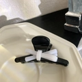 Detailaufnahme einer schwarzen Panda-Haarklammer mit weißer Schleife und Metallfeder - Schleife