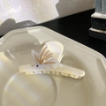 Eleganter cremefarbener Haarkrebs mit goldenen Linien für einen schicken Dutt-Look - Schmetterling