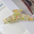 Détail d'une pince à cheveux papillon en acétate avec des strass étincelants et fini nacré - 11cm / Jaune