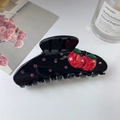 Détail d'une pince à cheveux noire avec cerises 3D et strass roses sur fond blanc - Grande Pince à Cheveux Cerise Noire
