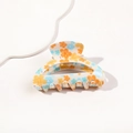 Detailansicht der cremefarbenen Haarklammer mit blau-orangem Blumenmuster - Orangefarbener Druck