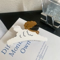 Dettaglio di un fermaglio per capelli a forma di cane teddy su un libro bianco - Bianco 9.5cm