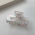 Macro shot of rectangular acrylic hair claw clip with colorful candy dots and metal spring - Square Clip