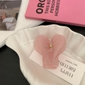 Nahaufnahme einer rosa Herz Haarklammer in einer Muschelschale mit Geburtstagskarte - Dunkelrosa Herzform
