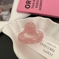 Detailansicht der rosa-durchscheinenden Herz-Haarklammer auf einem Dekotablett - Dunkelrosa Herz-Ausschnitt Stil