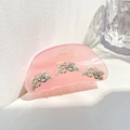 Pink translucent acrylic hair claw clip with white daisy patterns on a white surface - Daisy / Pink
