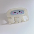 Macro detail of cartoon pufferfish hair claw clip with eyes and pink blush on cream finish - White Jellyfish