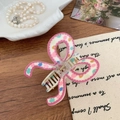 Detail of pink bow hair claw clip with colorful polka dots on a wooden table - Pink Polka Dot Pattern