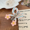 Detail of pink and blue striped bow hair claw clip with floral accents on wood - Pink White Blue Plaid