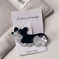 Detail der Corgi-Haarklammer aus marmoriertem Acetat auf einer weißen Markenkarte - Schwarz