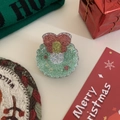 Nahaufnahme einer Weihnachtskranz Handyhalterung mit roter Schleife und Glitzer-Füllung - Weihnachtsblume