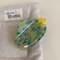 Dettaglio della molletta cactus in acetato verde marmorizzato con piccolo fiore giallo e strass - Cactus