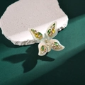 Eleganter Schmetterlings-Haarclip mit bunten Strasssteinen auf texturierter Steinfläche - Grün und Weiß