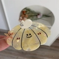 Dettaglio della molletta in acetato a forma di conchiglia con stella marina e mela - Forma a Conchiglia / Giallo